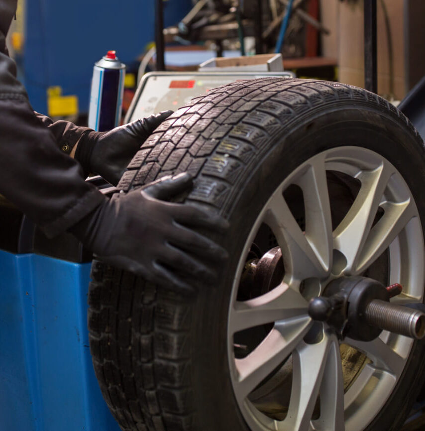 mechanic fitting a new tyre on a car wheel